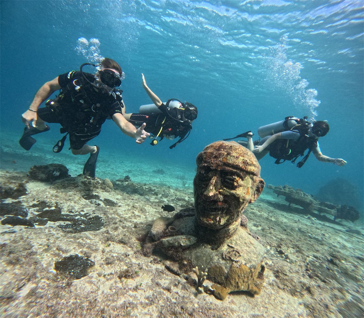 Buzos junto a una escultura sumergida en Cozumel